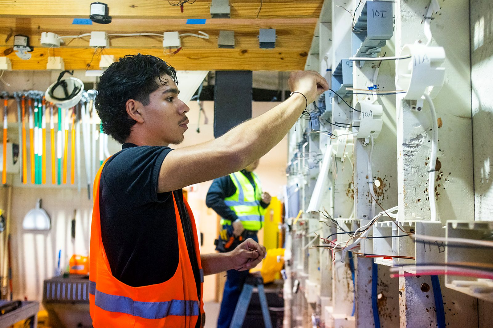 A student wiring an electrical training wall