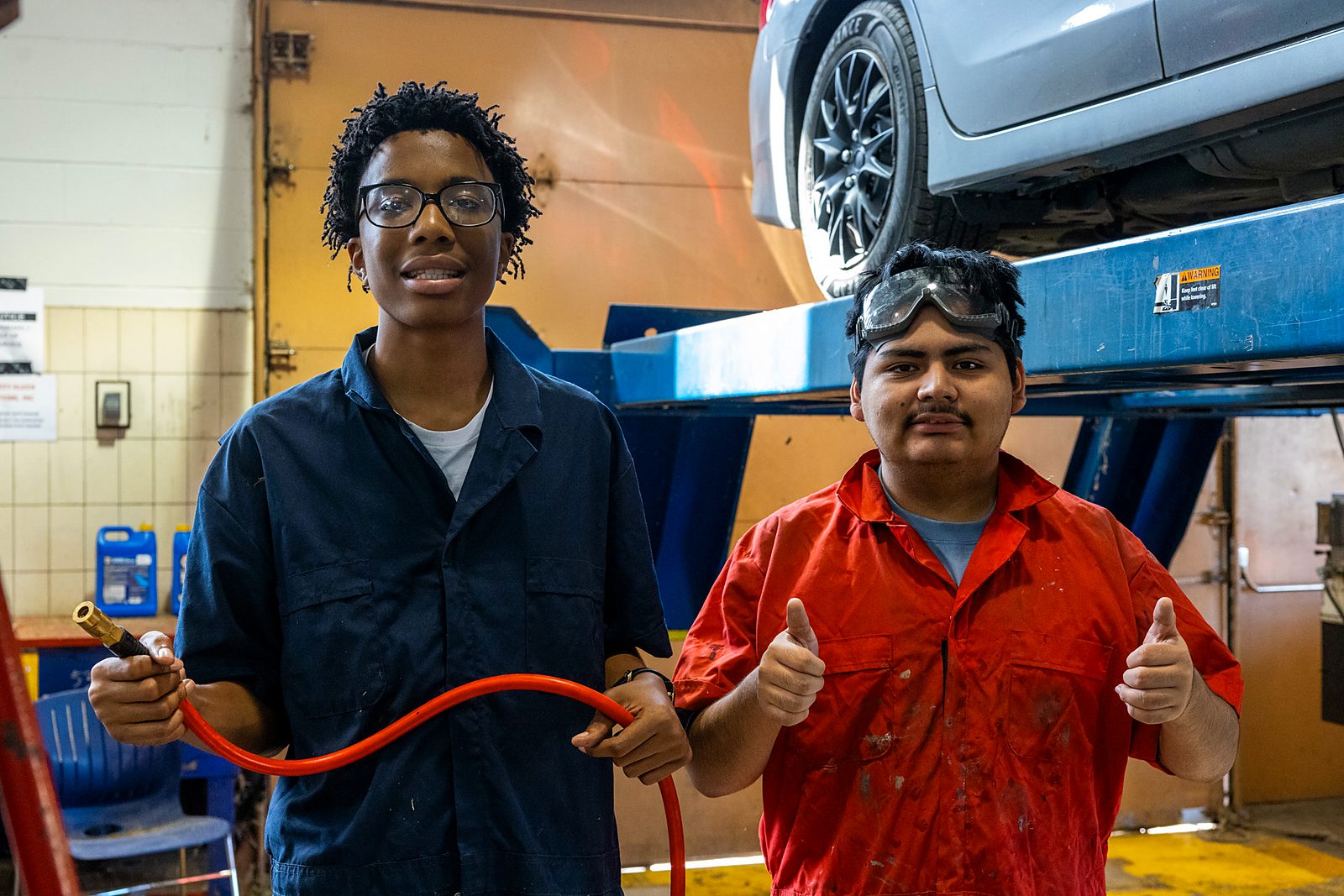 Two Richmond students smiling in an auto shop